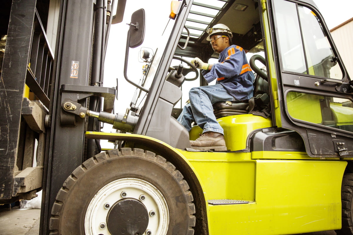 happy-men-with-tablet-pc-and-forklift-at-warehouse-PR2CLBG