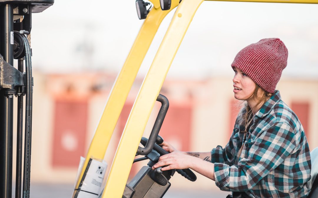 A woman operates a forklift at a job site