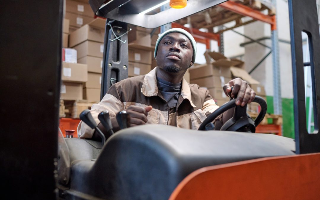 Warehouse worker driving in forklift