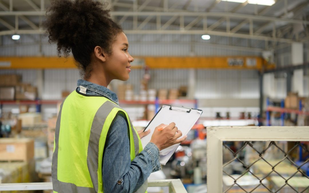 Female warehouse worker Counting items in an industrial warehouse