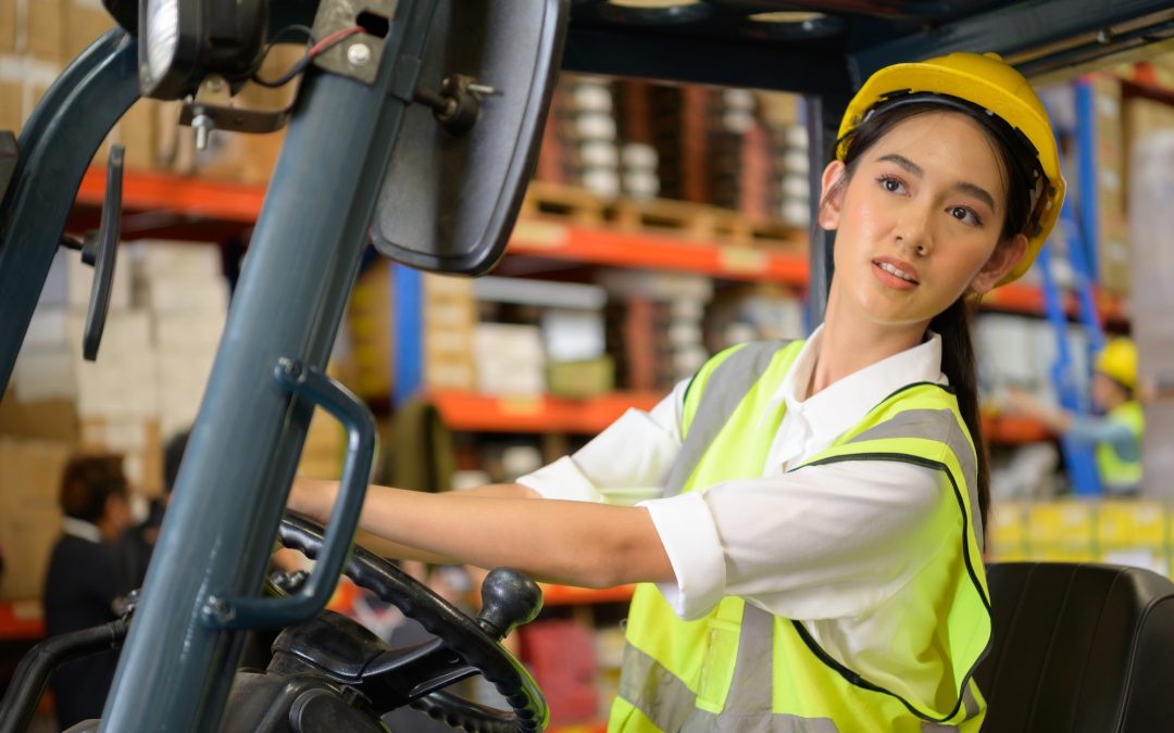 Female worker driving a forklift moving goods in the warehouse Practicing forklift operation