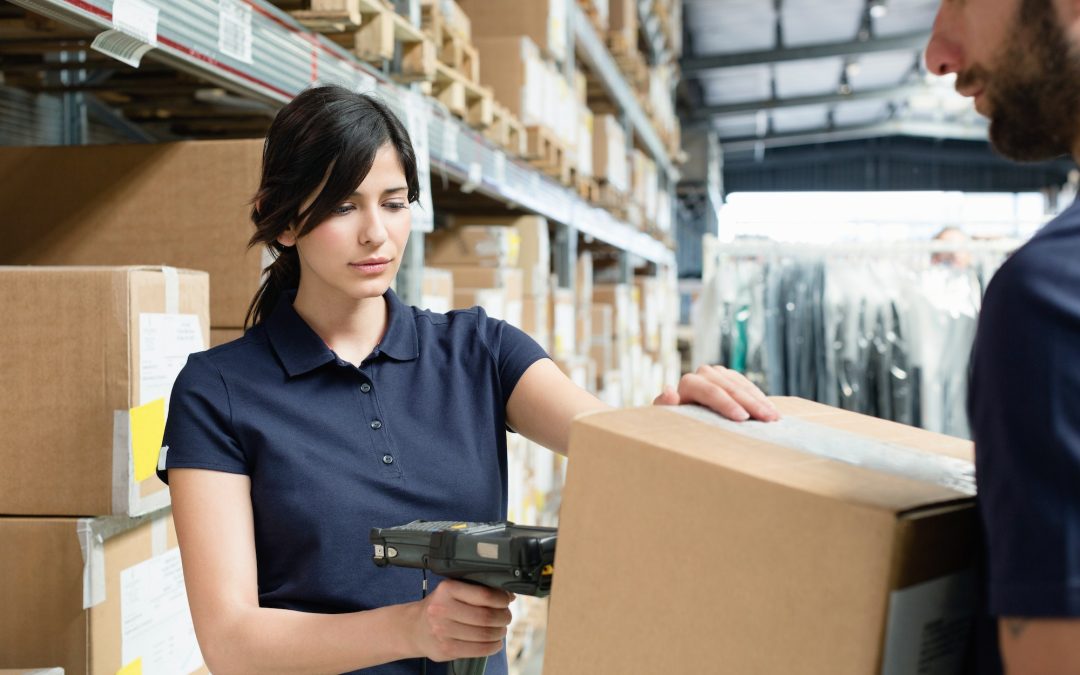 Warehouse workers using barcode scanner on box in distribution warehouse