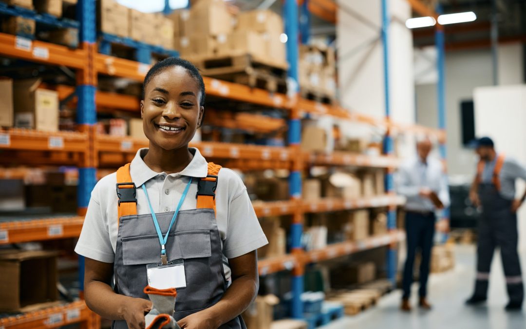 Happy black female worker at distribution warehouse looking at camera.