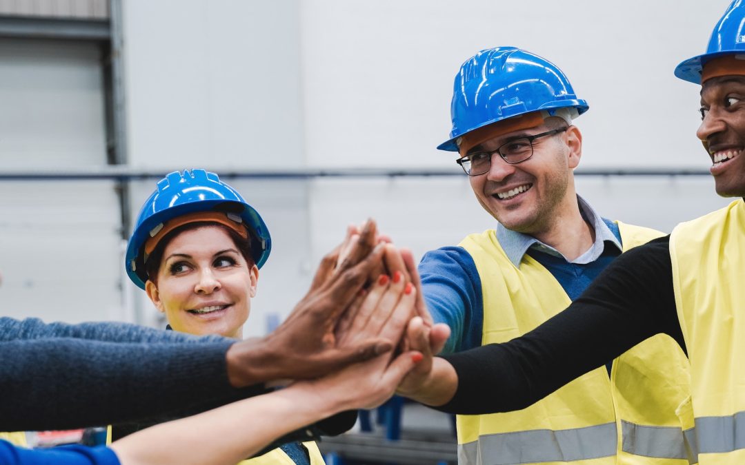 Happy multiracial engineer stacking hands while working at robotics warehouse