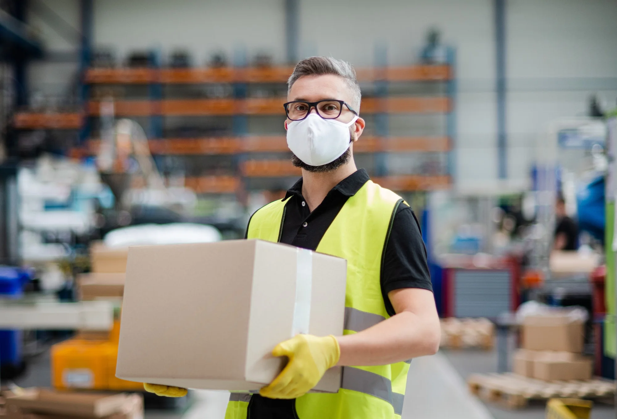 Man worker with protective mask working in industrial factory or warehouse Increasing Throughput: Strategies for Accelerating Material Flow in Your Warehouse