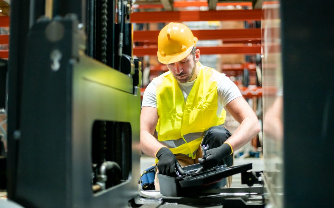 Mechanic repairing forklift in warehouse