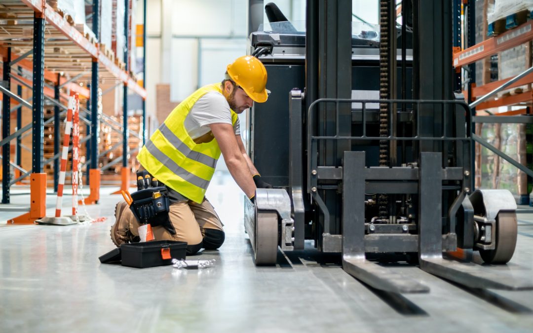 Mechanic repairing forklift in warehouse