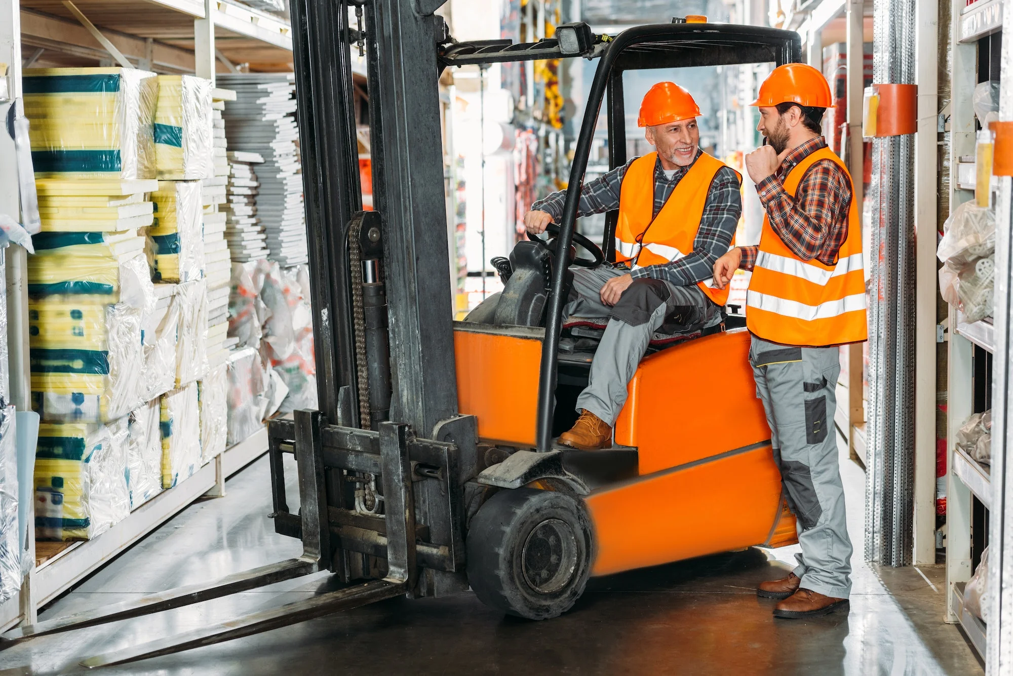 two male workers using forklift machine in storehouse two male workers using forklift machine in storehouse