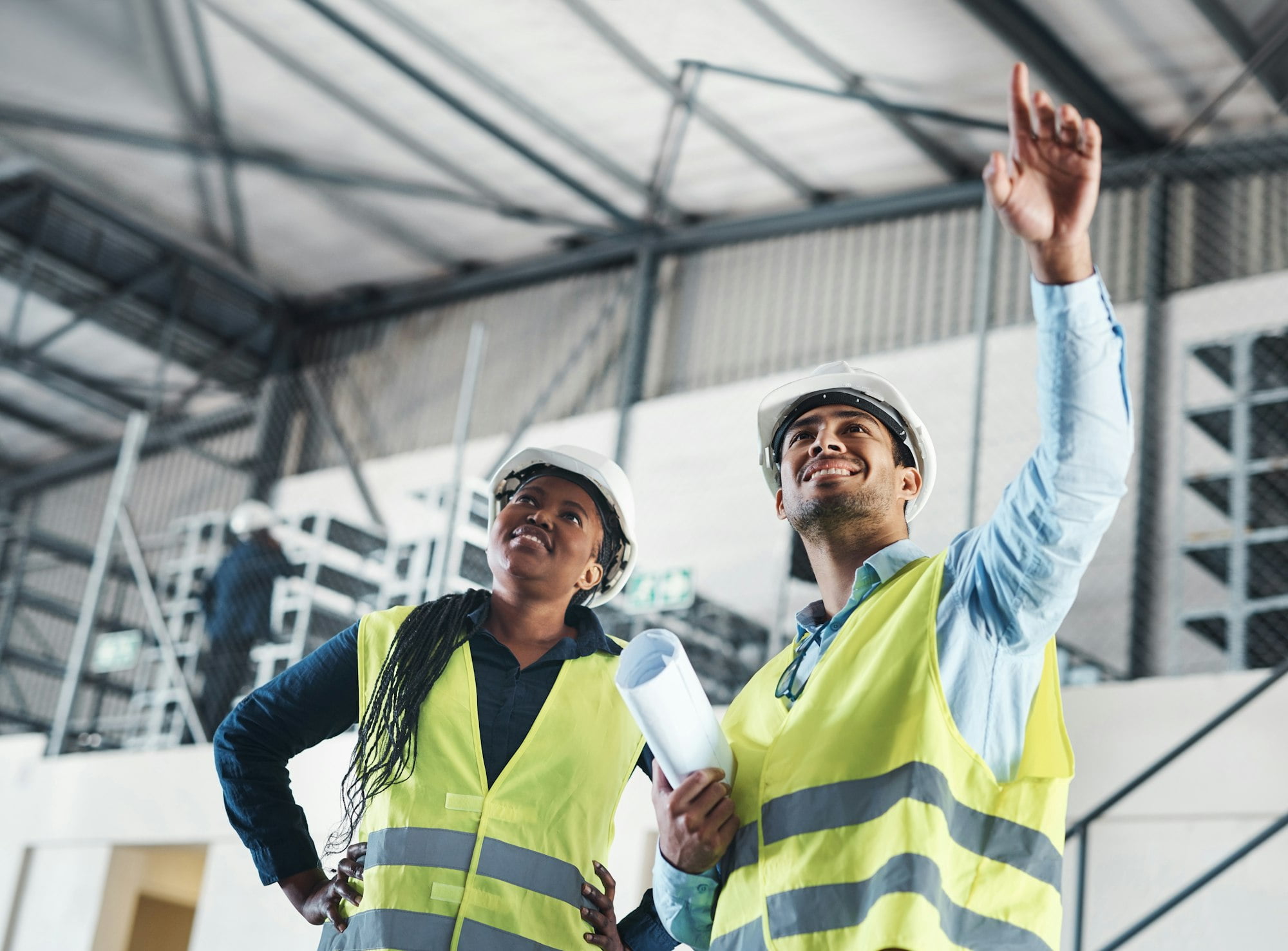 Shot of two young contractors standing together in the warehouse and observing the layout