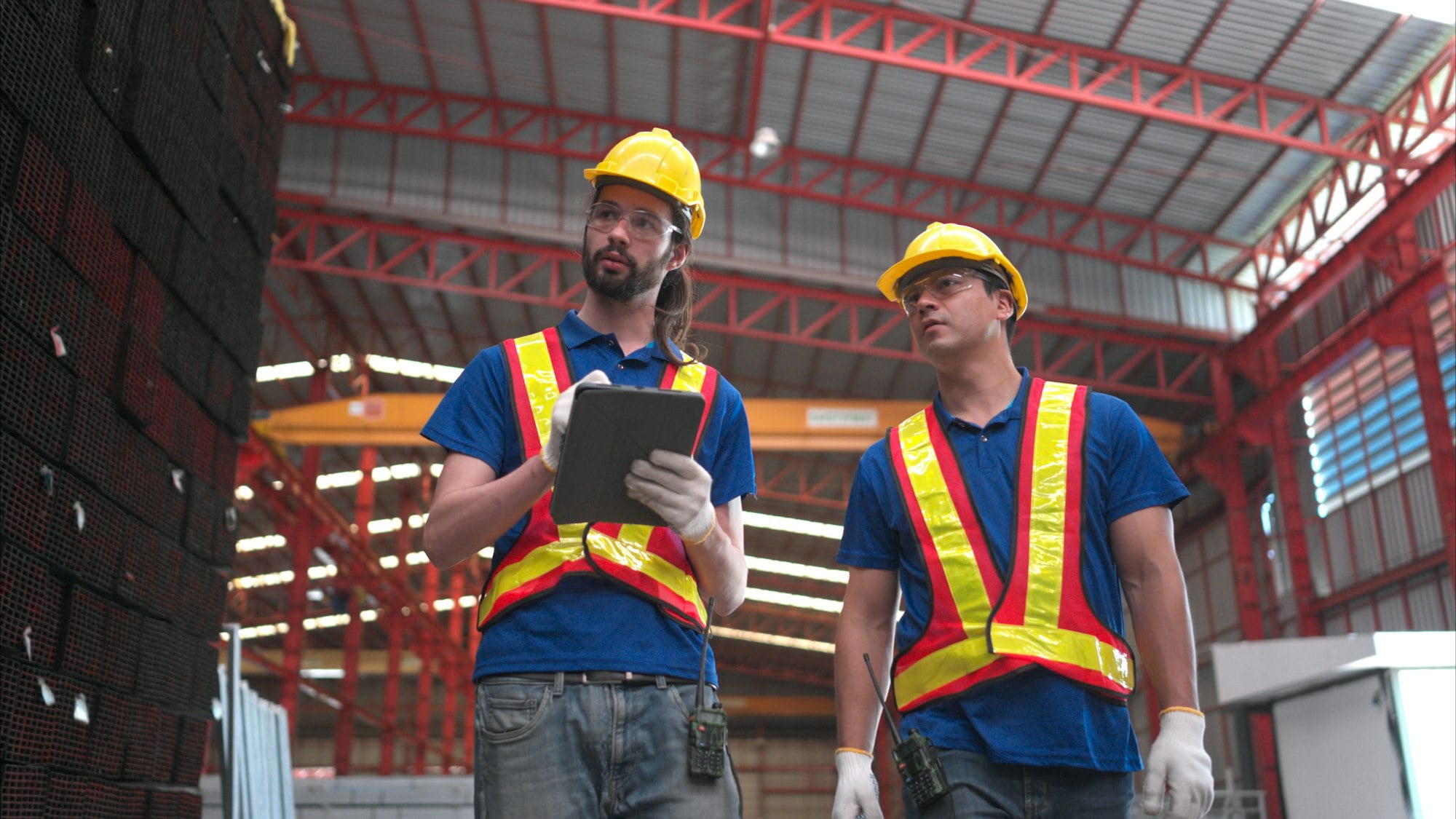 Warehouse workers in hard hats and helmets, Inspect and count steel in the warehouse.